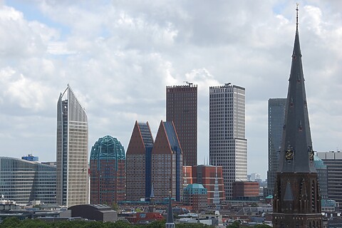 Verschillende hoge kantoortorens in het centrum van Den Haag. Met op de voorgrond een spitse kerktoren