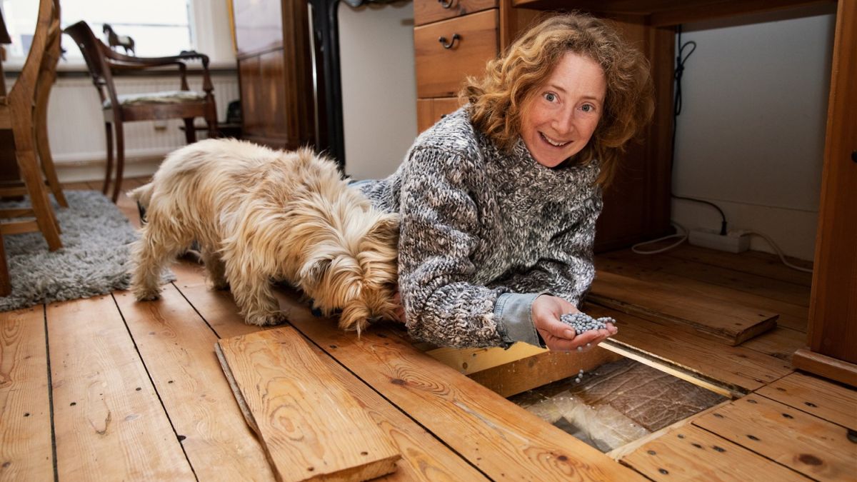 vrouw ligt op vloer met isoleermateriaal in hand