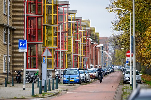 Straat met kleurrijke huizen en fietser in Laak