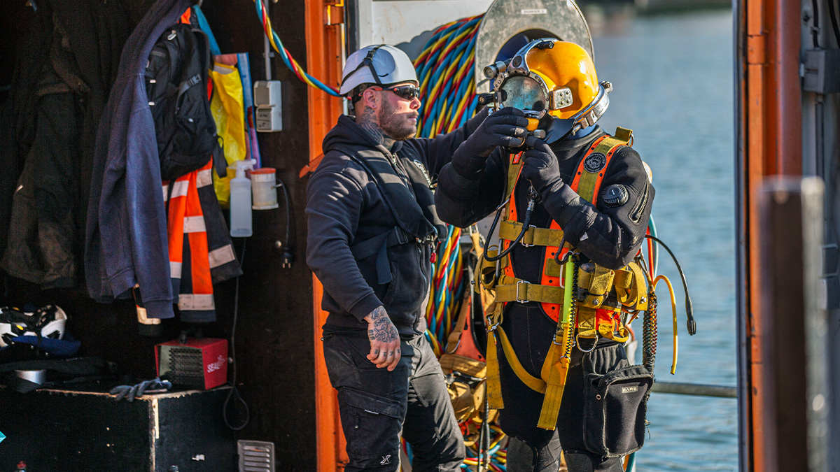 Werklieden bij de Dr. Lelykade voor werkzaamheden in het water.