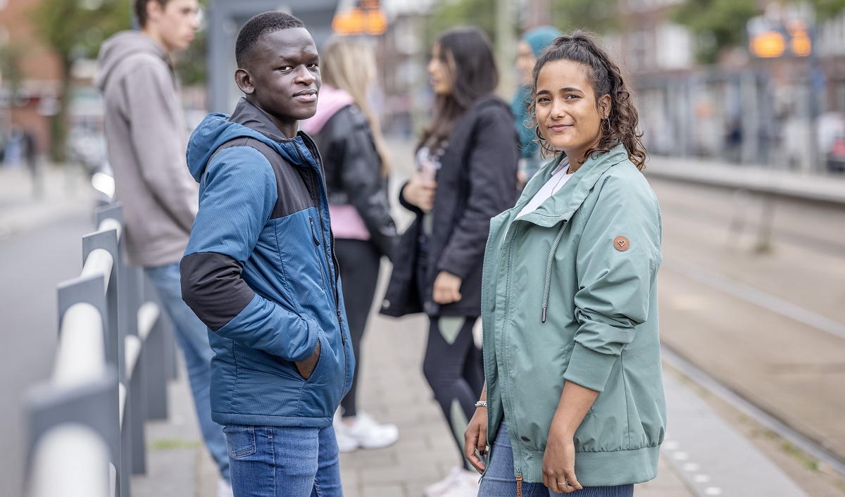 2 jonge mensen staan bij tramhalte