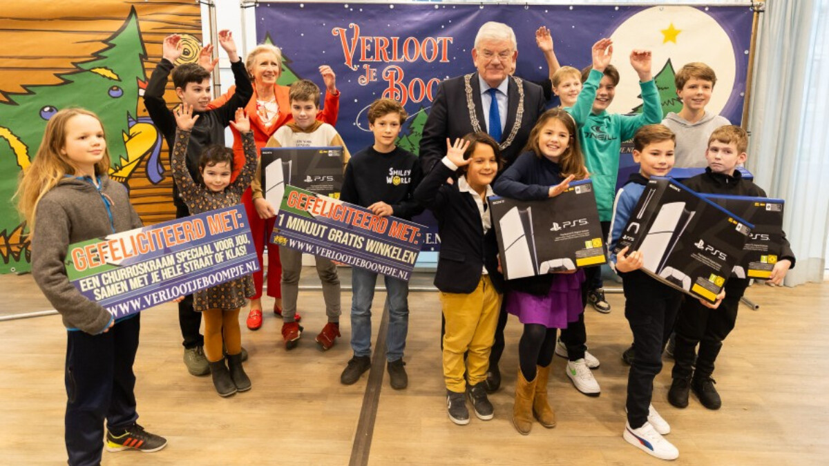 Foto van burgemeester Van Zanen en kinderen tijdens de prijsuitreiking van Verloot je boompje.