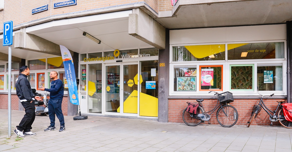 2 personen staan bij ingang wijkcentrum Cromvlietplein