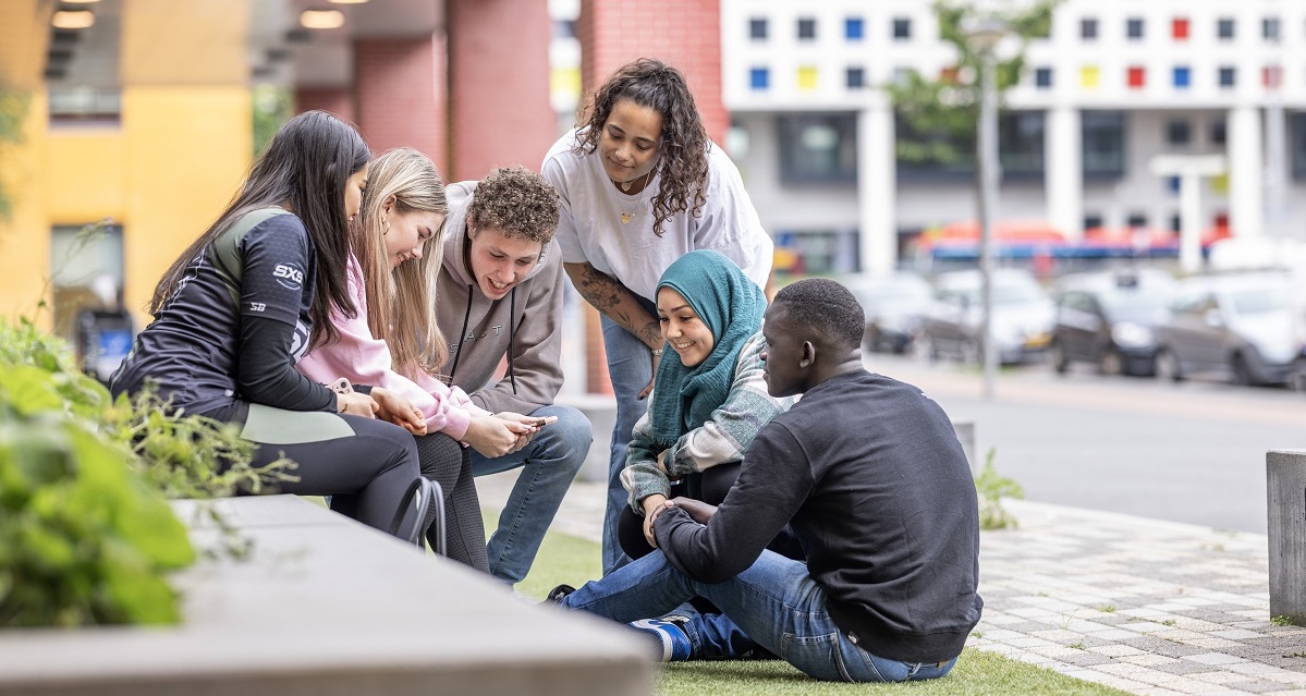 Groepje van 6 jongeren bij schoolgebouw