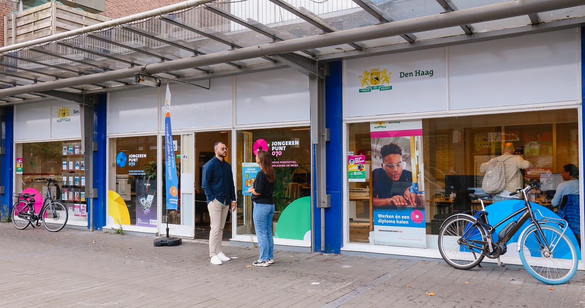 2 mensen staan bij de ingang van Jongerenpunt070 Escamp