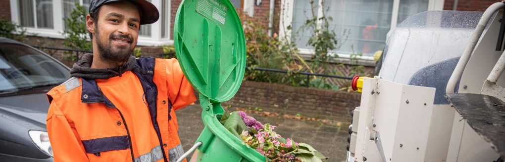 HMS employee empties organic waste bin into garbage truck