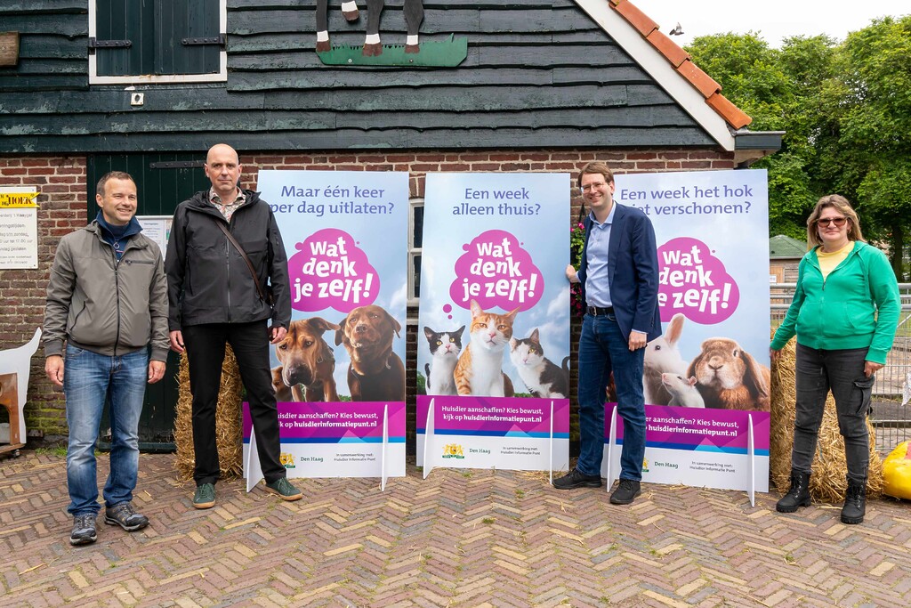 Wethouder Barker met campagneposters voor dierenwelzijn